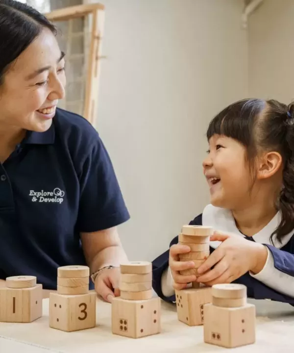 Childcare smiling with child playing with toys