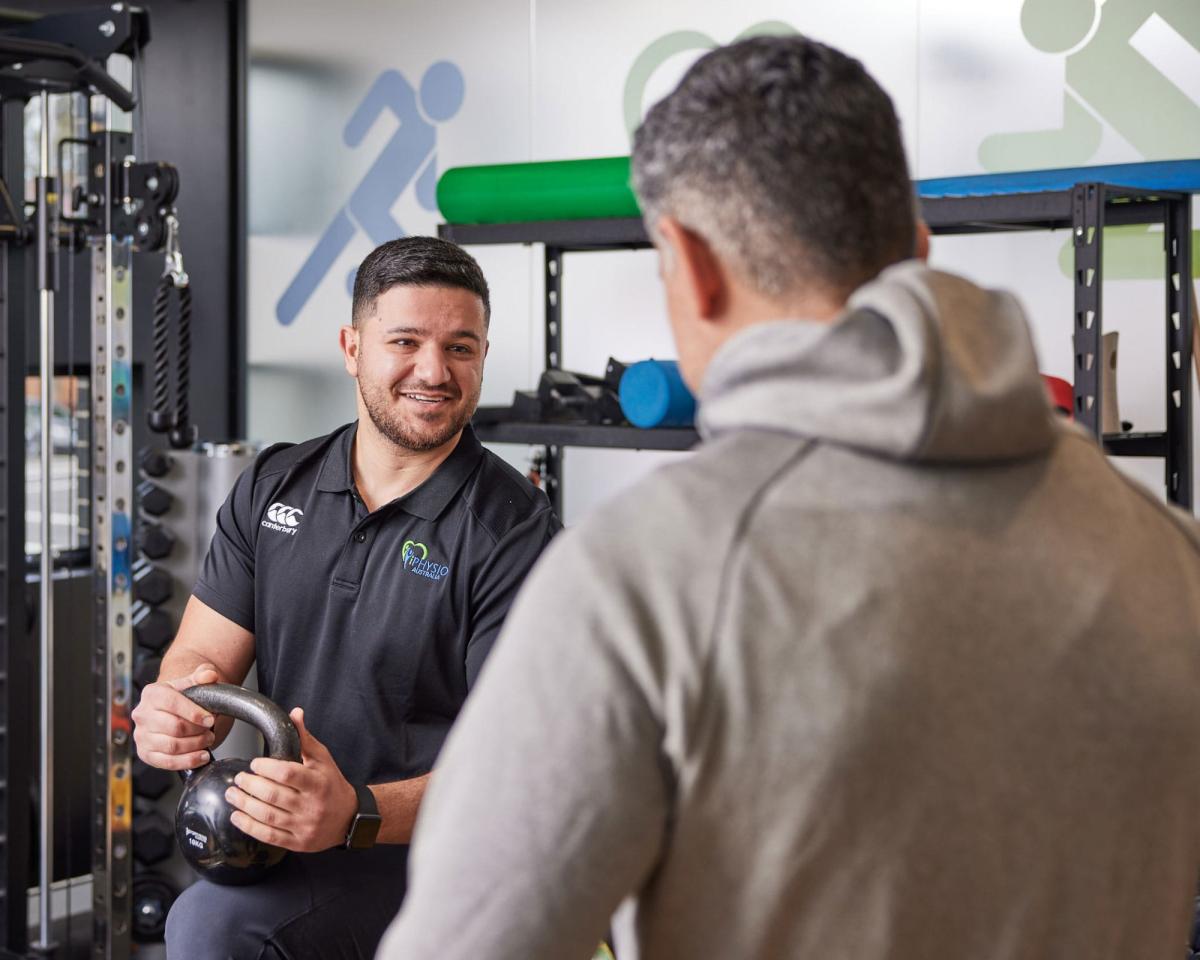 iPhysio staff with weight talking to customer