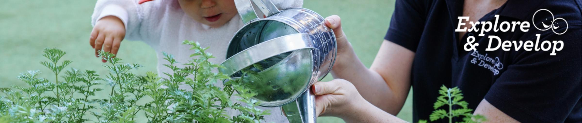 Adult and child using a watering can. 
