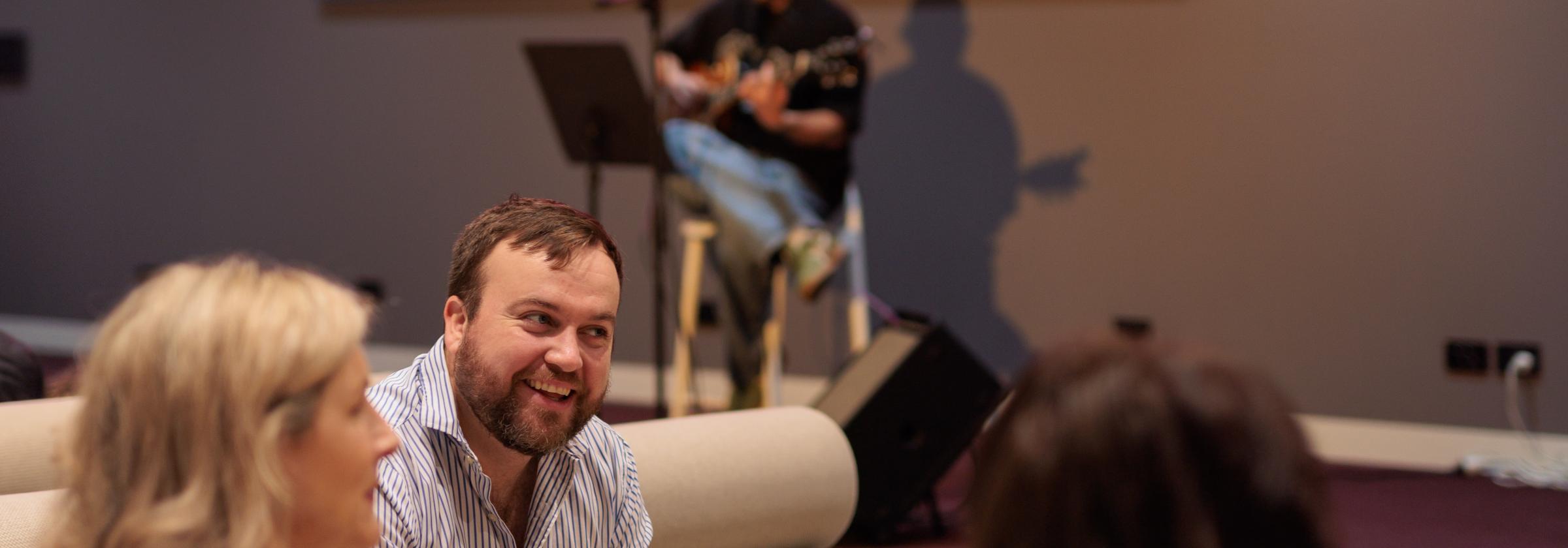 People talking with performer in the background