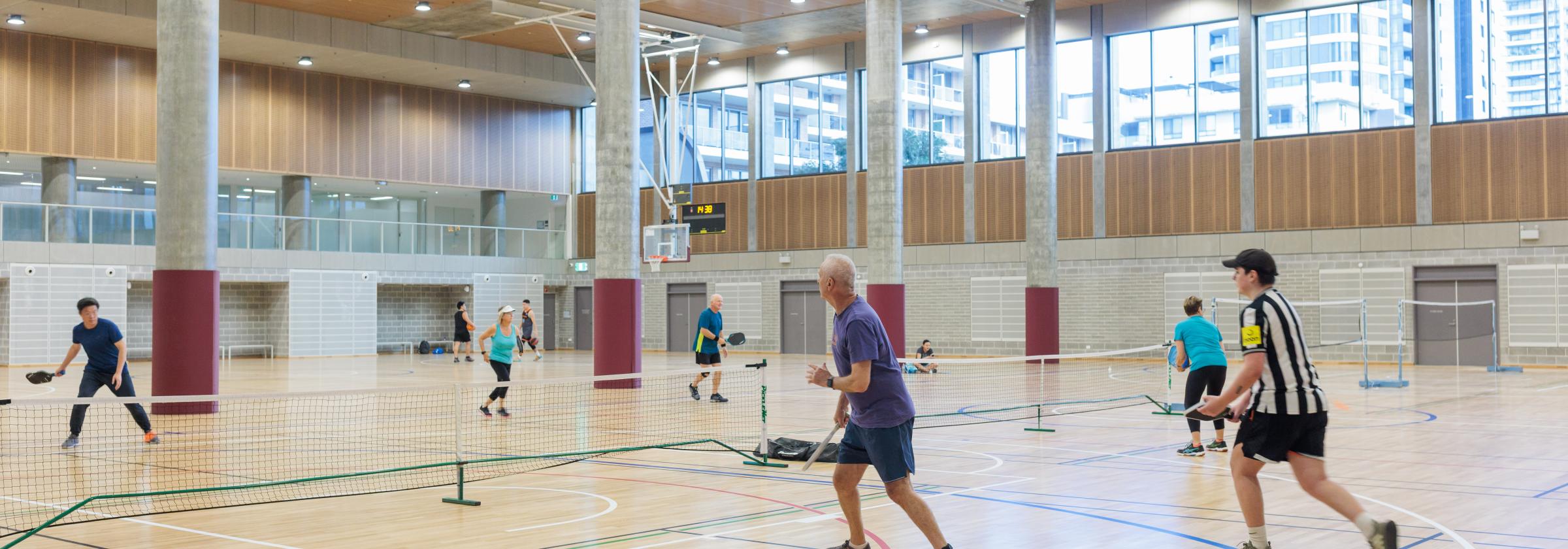 People playing tennis in indoor court