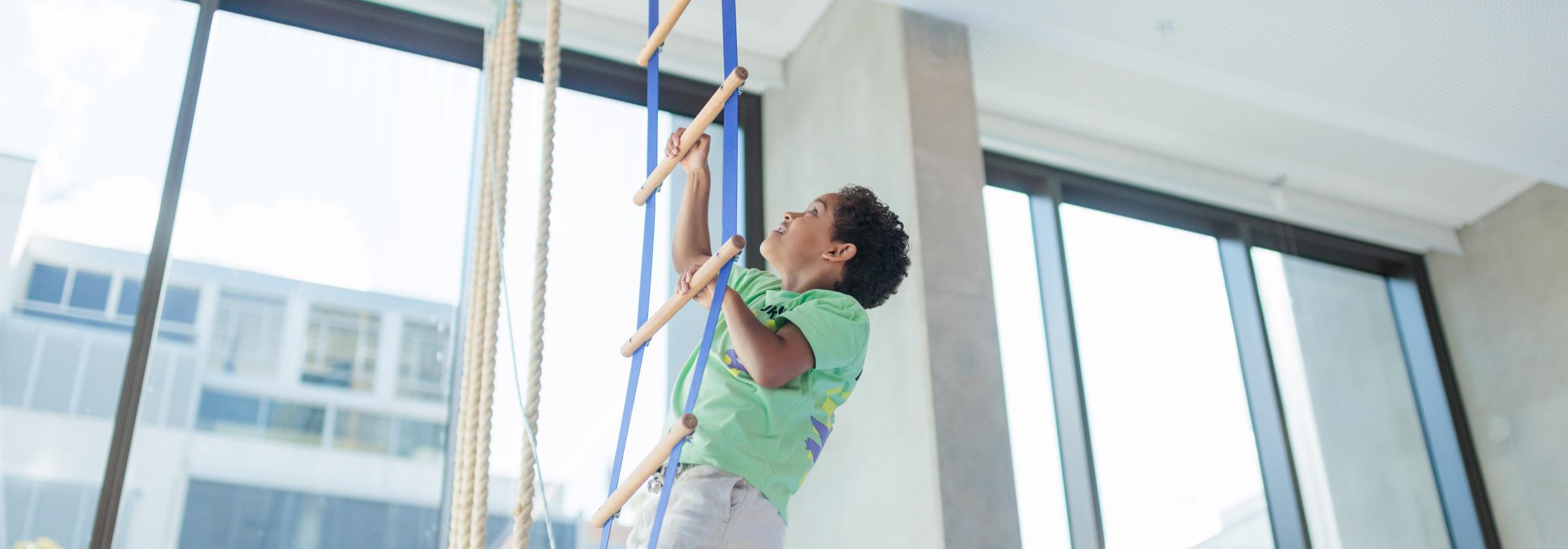 Boy climbing rope ladder gymnastics